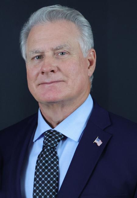 Middle aged white man wearing blue suit, shirt and tie