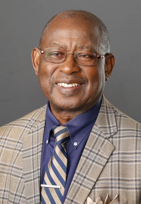 Black man wearing grey suit with blue shirt and striped tie