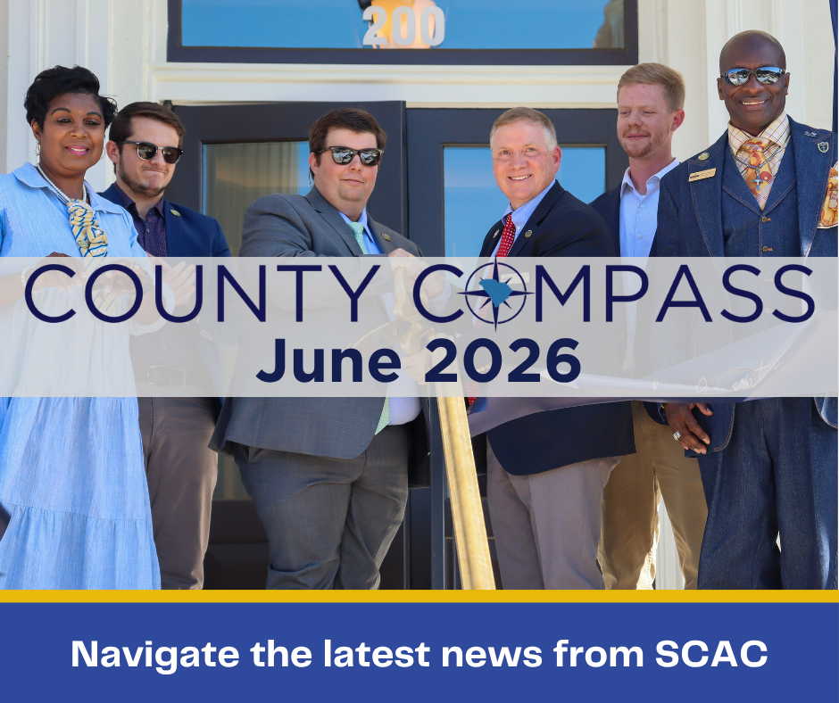 The County COMPASS logo is superimposed over an image of a group of people cutting a ribbon in front of a courthouse.
