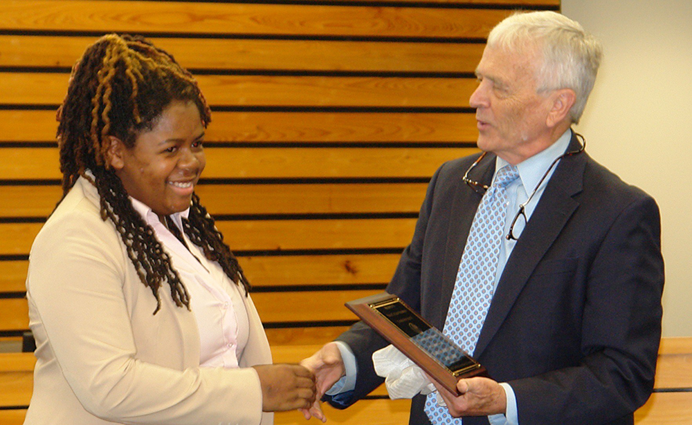 A scholarship winner accepts her award at a school event