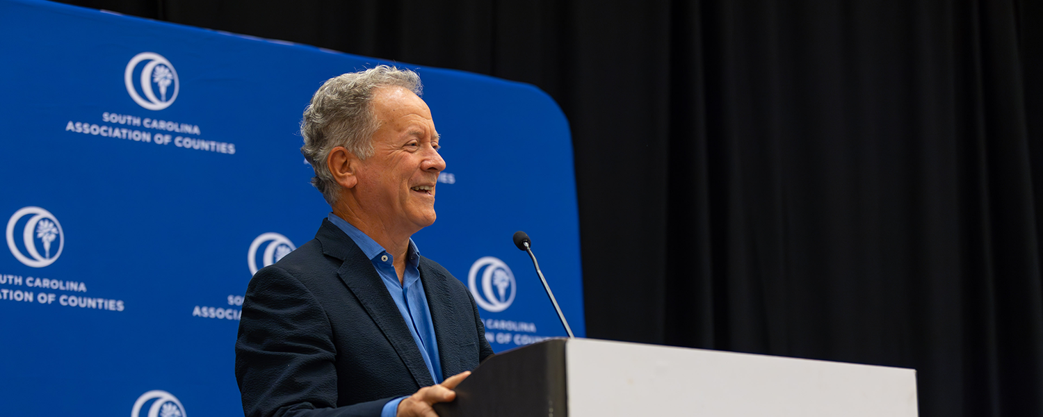 Former South Carolina Gov. David Beasley speaks at a podium during the 2024 SCAC Annual Conference.