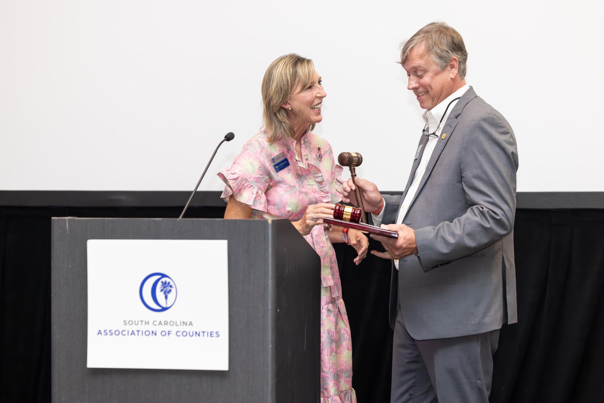 Immediate SCAC Past President and Chesterfield County Council Chairwoman Mary D. Anderson passes the gavel to 2026-27 SCAC President Cecil M. Thornton Jr., vice chairman of Calhoun County Council.
