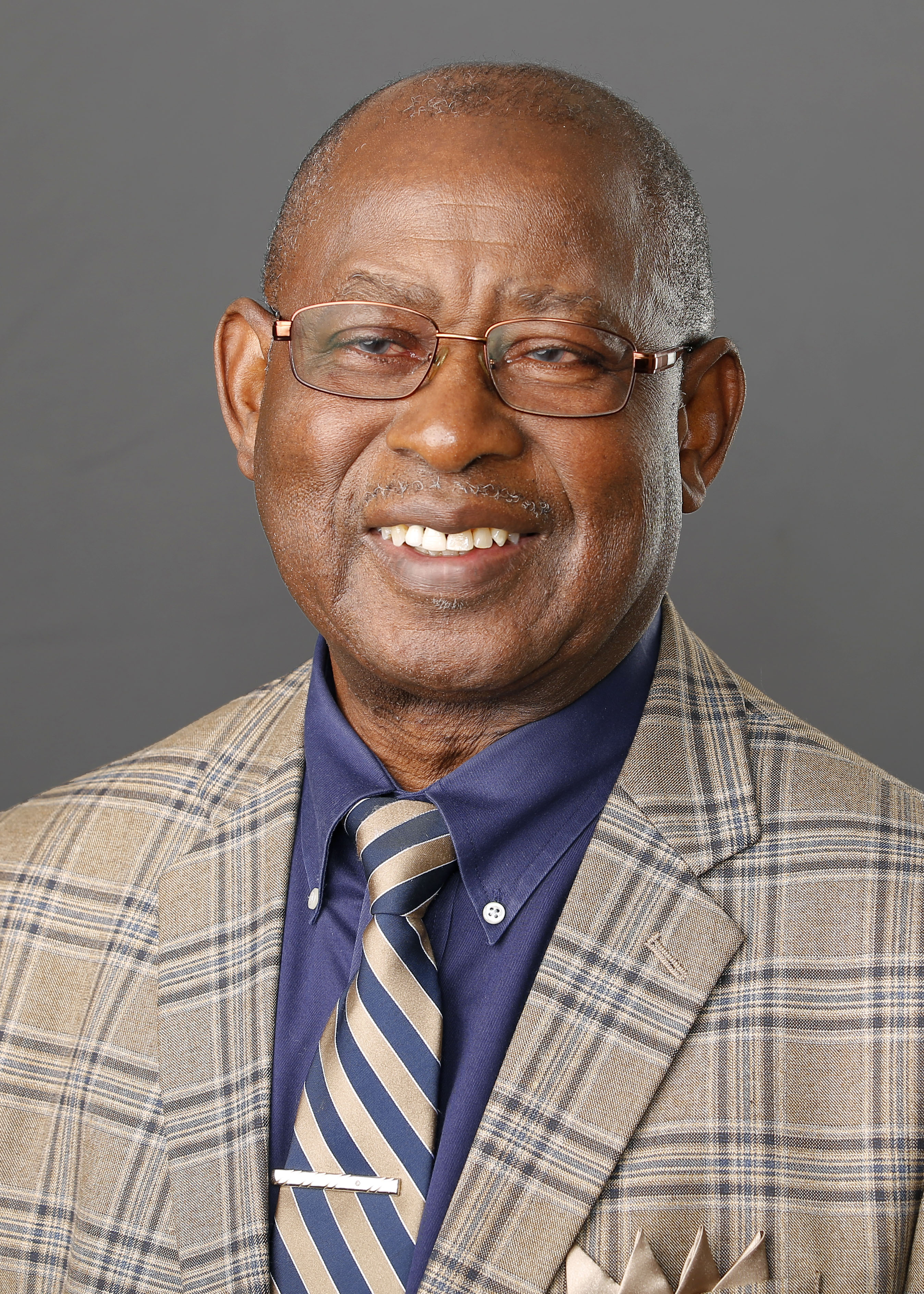 Black man wearing grey suit with blue shirt and striped tie